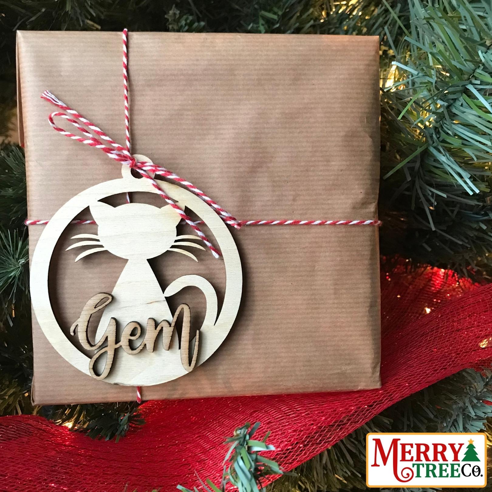 brown paper gift with red and white string has wooden cat ornament attached.