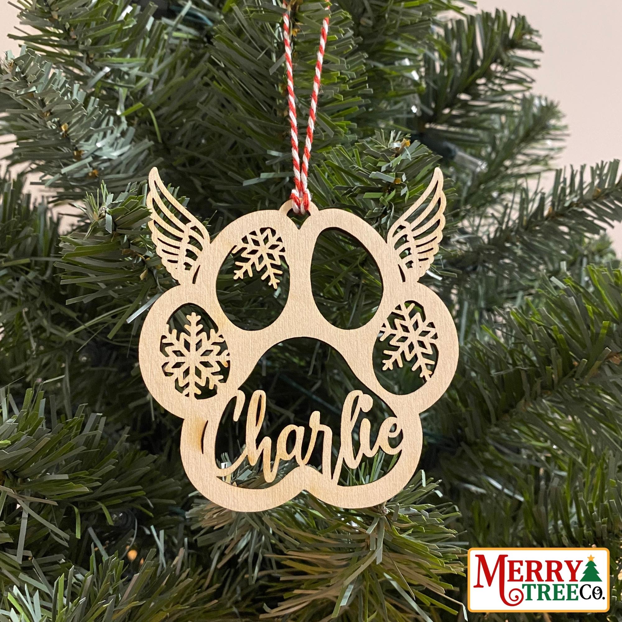 Paw print with angel wings on top hangs on a tree.