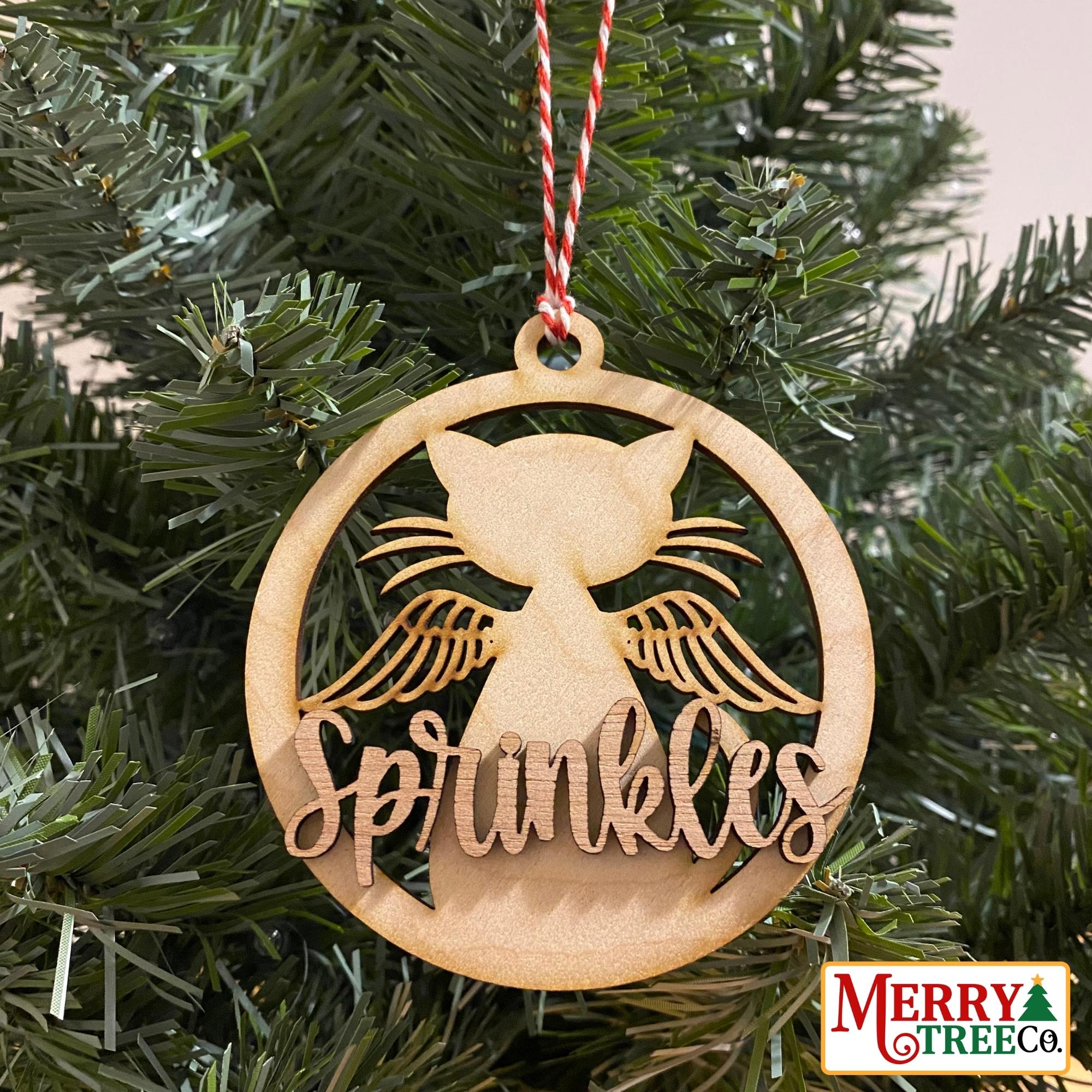 Circular wood ornament with cat with wings. 